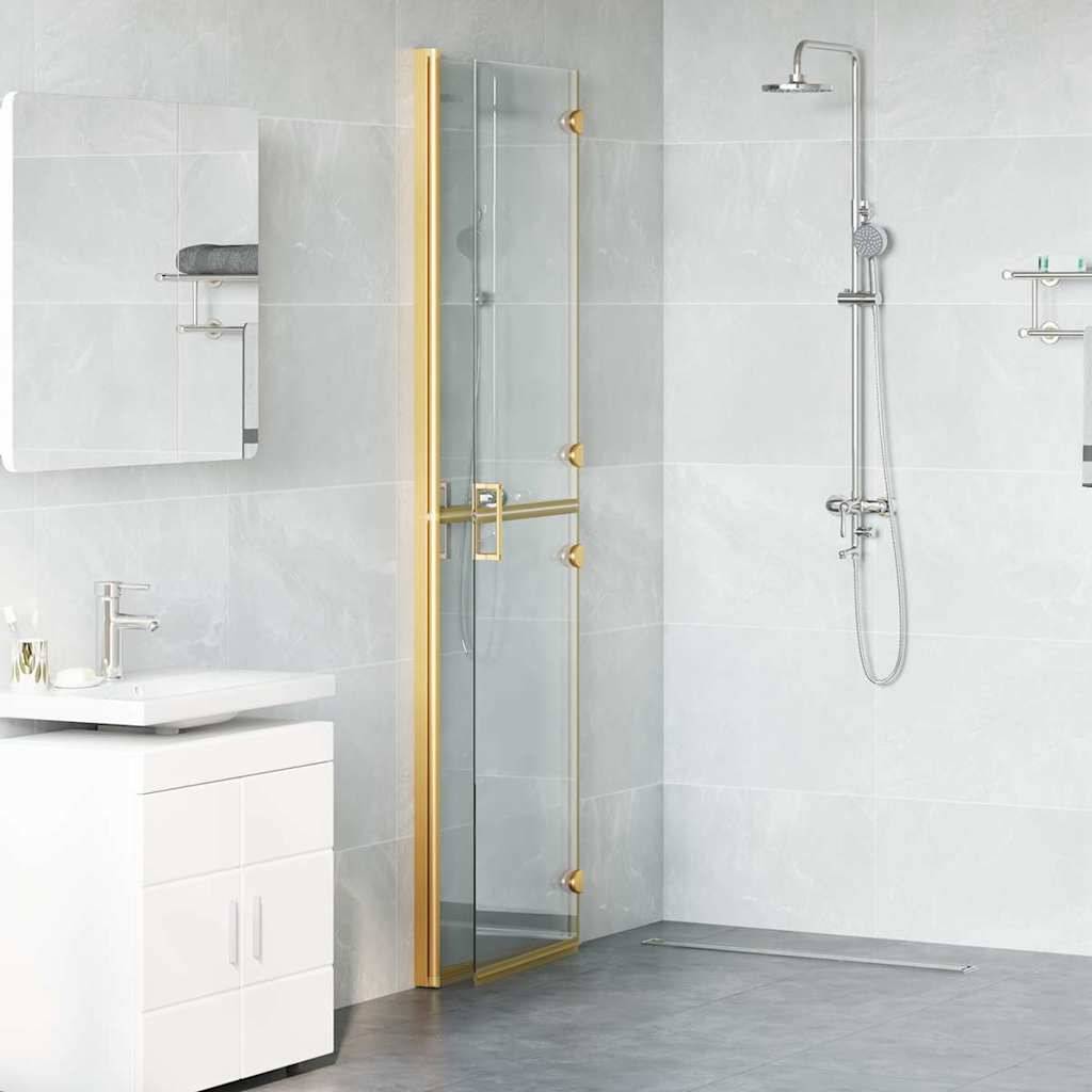 Modernes Badezimmer mit einer Dusche mit goldenem Rahmen und Glastür, wandmontiertem Duschkopf, weißem Waschbecken mit Unterschrank und einem Handtuch auf einem Regal.