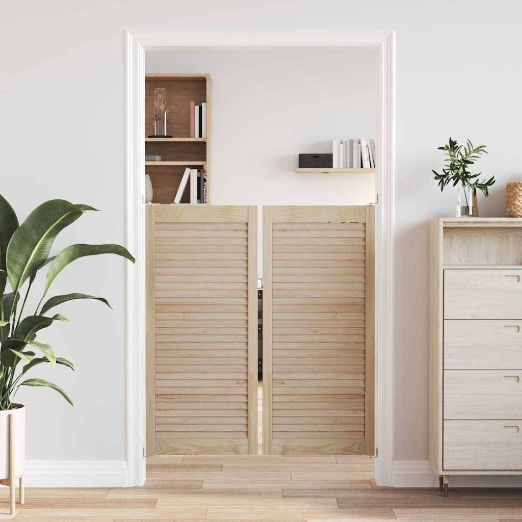 Ein heller, luftiger Raum mit halber Höhe ausgeführten Holz-Saloon-Türen, einer großen Pflanze links und einer hellholzfarbenen Kommode rechts an einer weißen Wand.