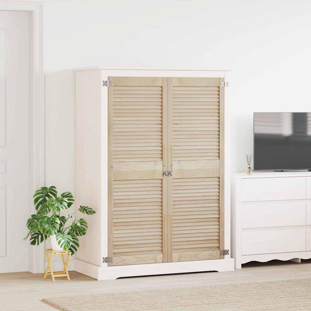 Ein weißer Raum mit einem Holzkleiderschrank, einer Topfpflanze auf einem Ständer und einer Kommode mit einem Fernseher darauf. Der Boden ist mit einem hellen Teppich bedeckt.