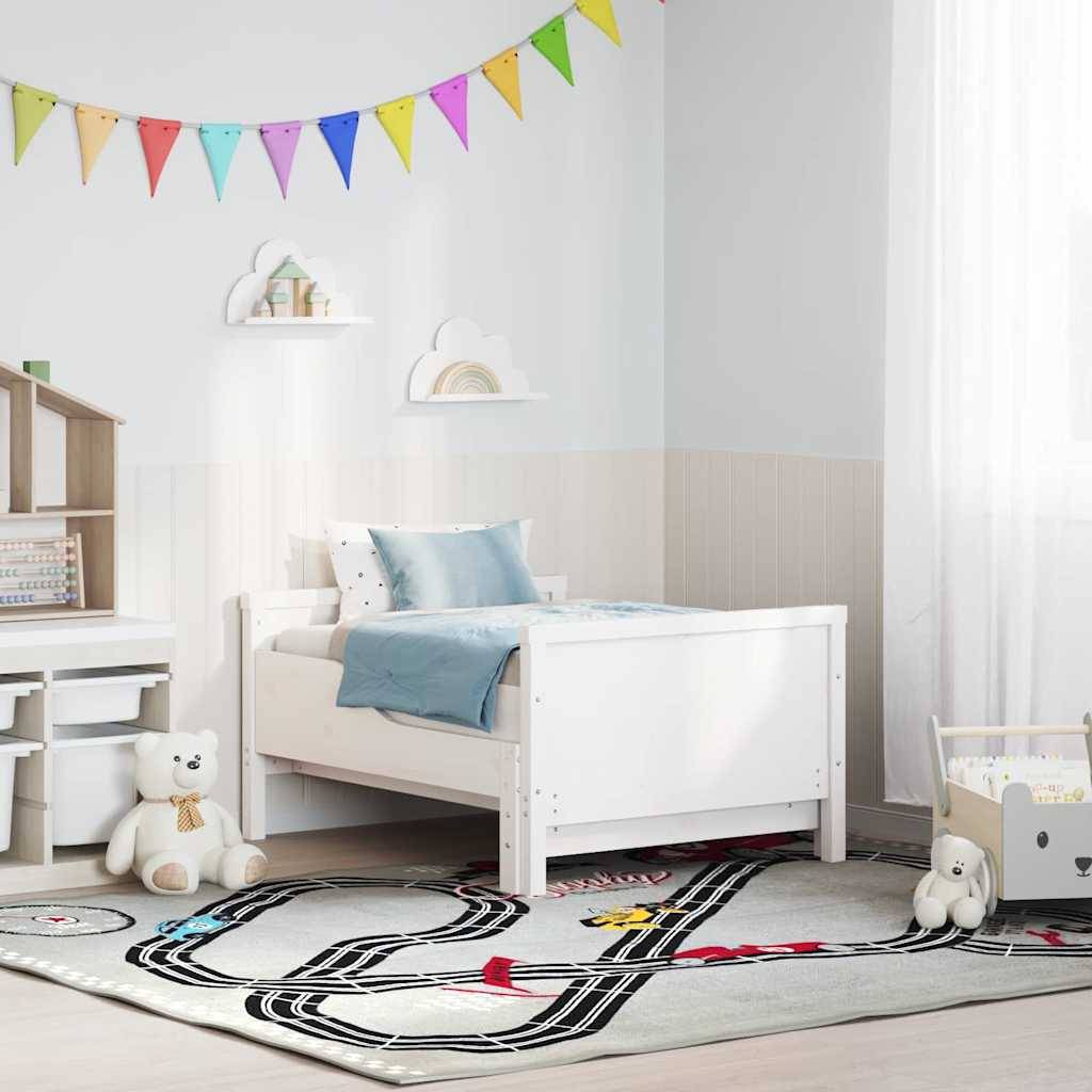 Helles Kinderzimmer mit weißem Bett, Kuschelbär, Wimpelkette, Regalen und Teppich mit Straßenmuster