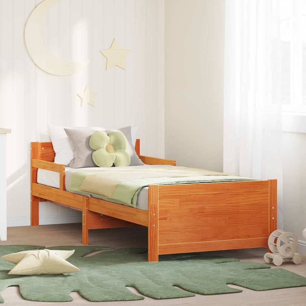 Einzelnes Holzkinderbett in einem hellen Raum, gestylt mit grüner Bettwäsche, Stern-Wanddeko, einem Blatt-Teppich und einem Spielzeugflugzeug.