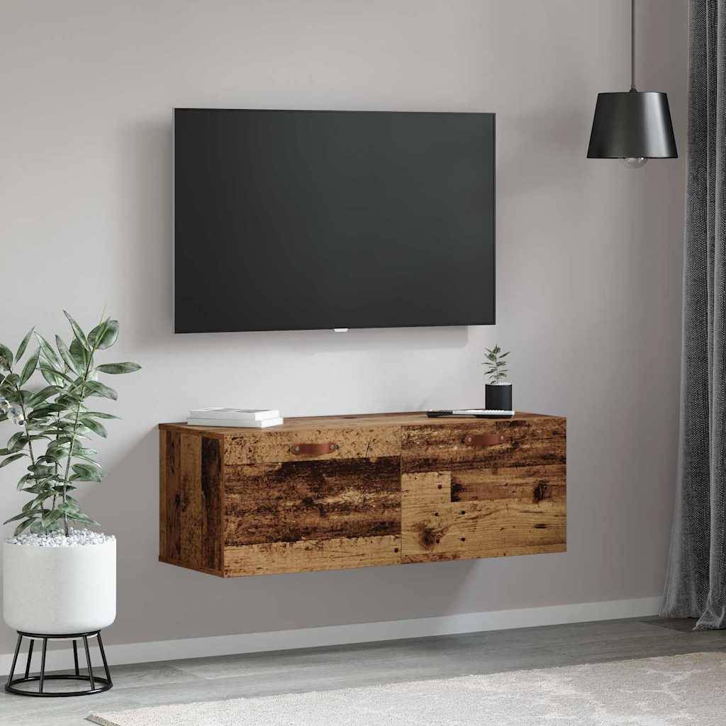 Wandmontierter Fernseher über einem Holzkonsole mit Büchern und einer Pflanze darauf; eine Topfpflanze steht links auf dem Boden und sorgt für eine gemütliche Wohnatmosphäre.