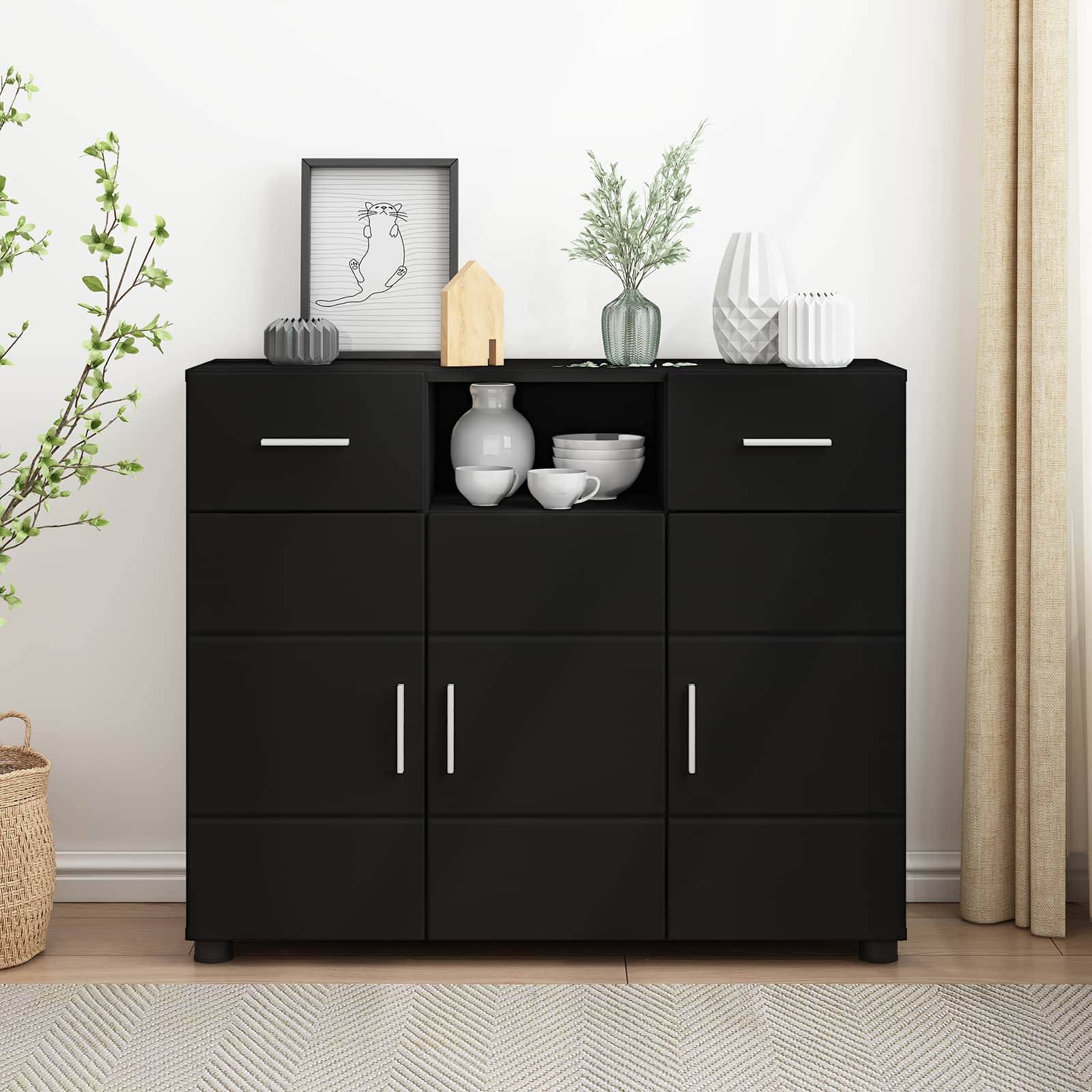 Schwarzer dreitüriger Schrank mit weißen Griffen, gekrönt mit rahmenkunst, Vasen, Schüsseln und kleiner Dekoration gegen eine helle Wand.
