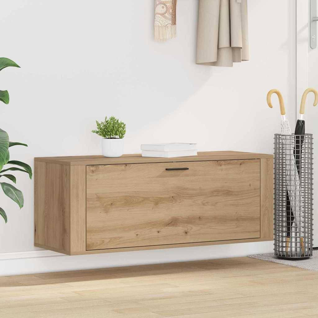 Eine Holzwandschrank unter einem Ständer mit Mantel- und Regenschirmhalter rechts. Eine kleine Pflanze und ein Buch liegen oben darauf.