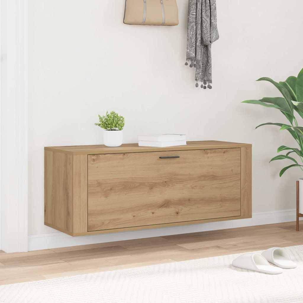 Ein hölzerner, an der Wand montierter Schrank mit einer Topfpflanze und einem Buch darauf. Ein grauer Handtuch hängt daneben. Minimalistische Einrichtung in einem hellen Raum.