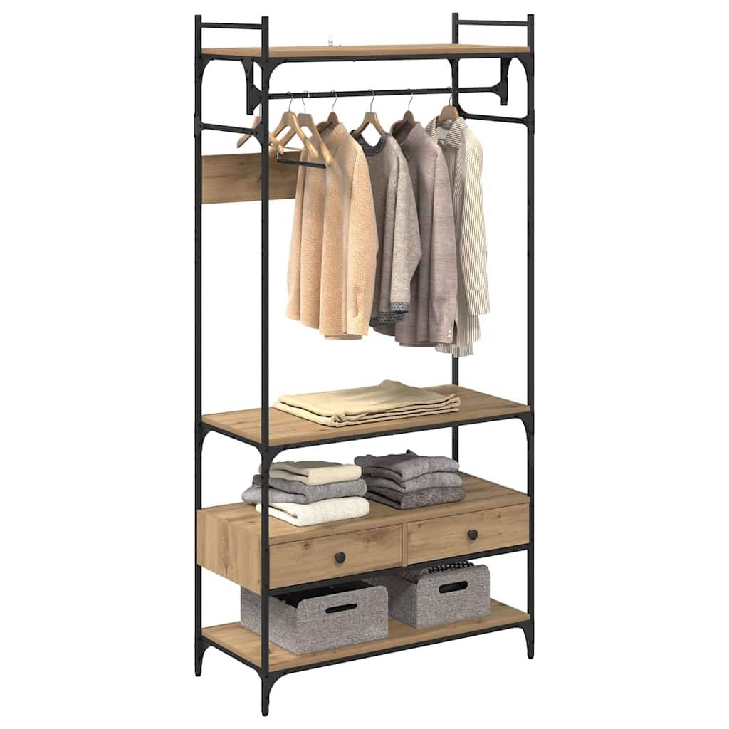 Ein Kleiderschrank aus Holz und Metall mit offener Konstruktion, an dem Kleidungsstücke hängen, gefaltete Pullover auf einem Regal und Aufbewahrungskörbe darunter.