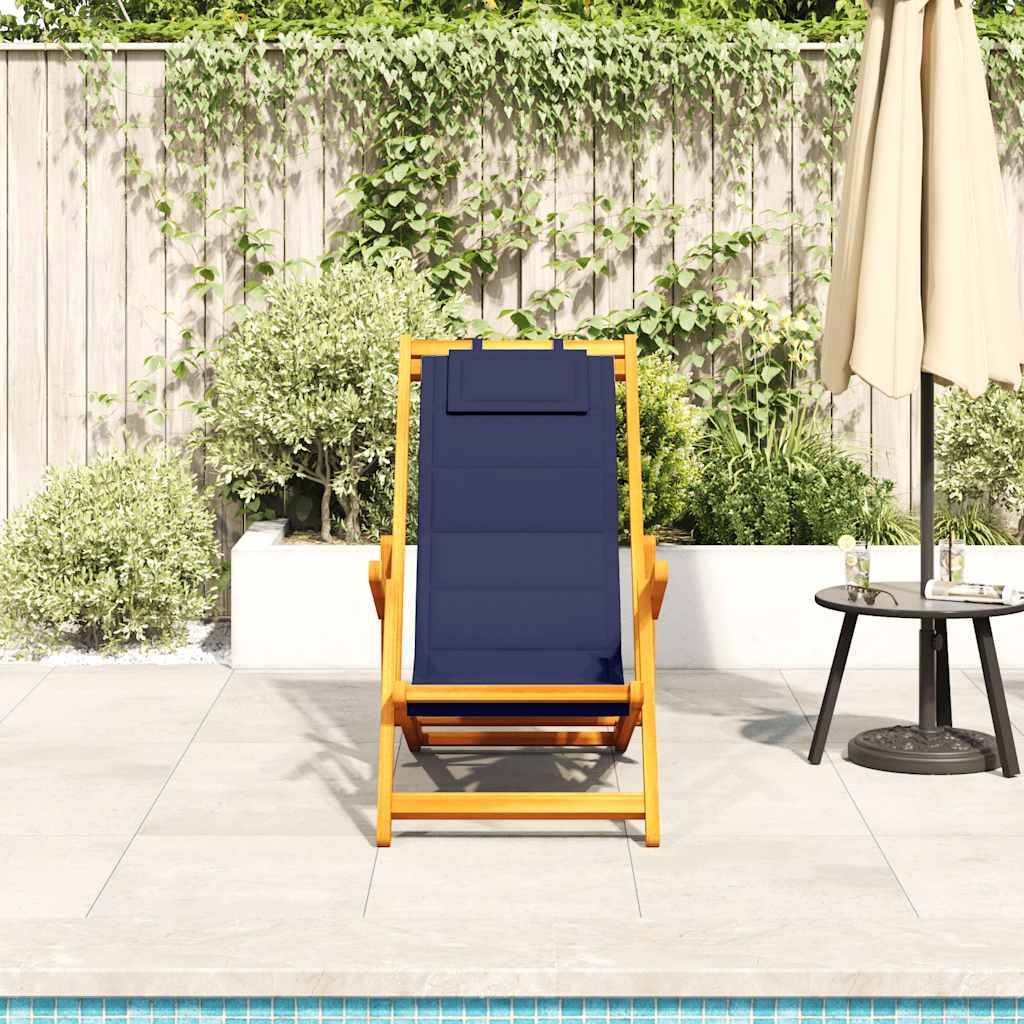 Ein Holzliegestuhl mit einem blauen Kissen steht neben einem Pool, flankiert von einem kleinen Tisch mit Getränken und einem Sonnenschirm. Üppiges Grün im Hintergrund.