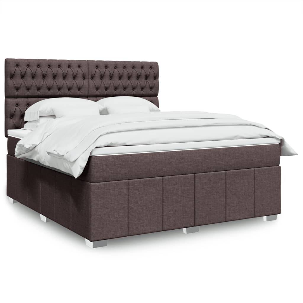 Ein plüschiges, modernes Bett mit einer gesteppten Kopfseite und weißer Bettwäsche, das auf einem Podest-Gestell mit sichtbaren Beinen in einem hell beleuchteten Raum steht.