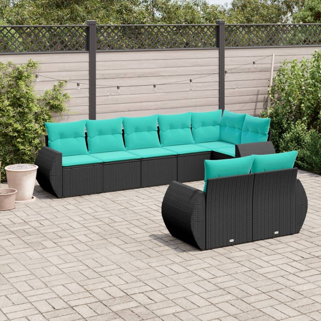 Outdoor-Terrasse mit grauen Pflastersteinen, ausgestattet mit einem schwarzen Rattansofa-Eckset mit leuchtend türkisfarbenen Kissen. Umgeben von Grünpflanzen und einem Sichtschutzzaun.