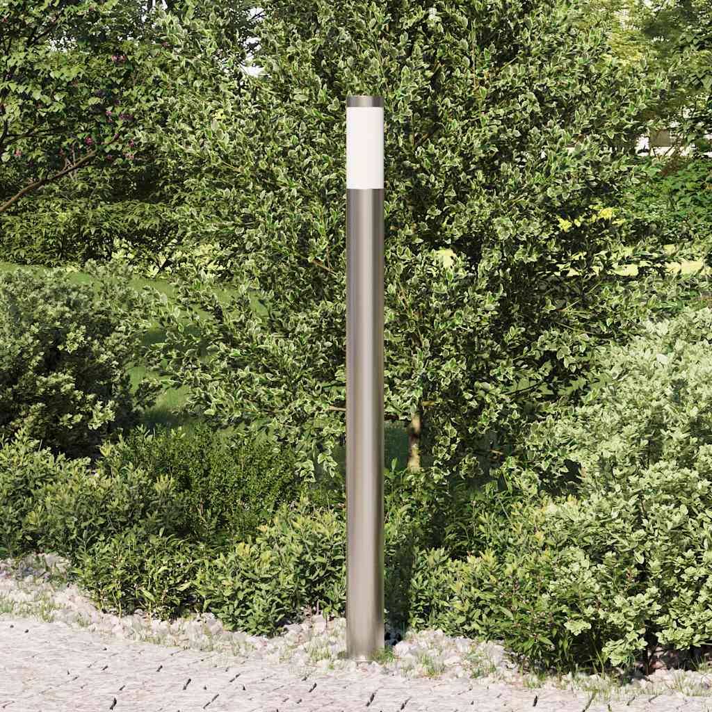Eine moderne Außenlampe steht in einem üppig grünen Garten mit verschiedenen Pflanzen und einem Steinweg im Vordergrund.