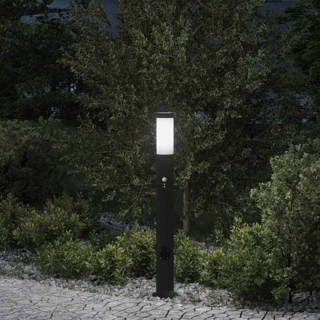 Eine beleuchtete Gartenlaterne erhellt einen Steinweg, der von üppigem Grün und Bäumen umgeben ist und eine friedliche nächtliche Gartenszene schafft.