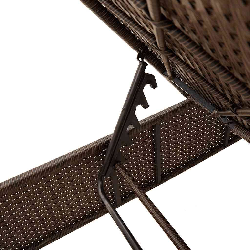 Nahaufnahme eines gefalteten braunen Rattanpatio-Stuhls mit sichtbarem Metallscharnier und Stützstruktur, die seine Transportfähigkeit und sein Design verdeutlicht.