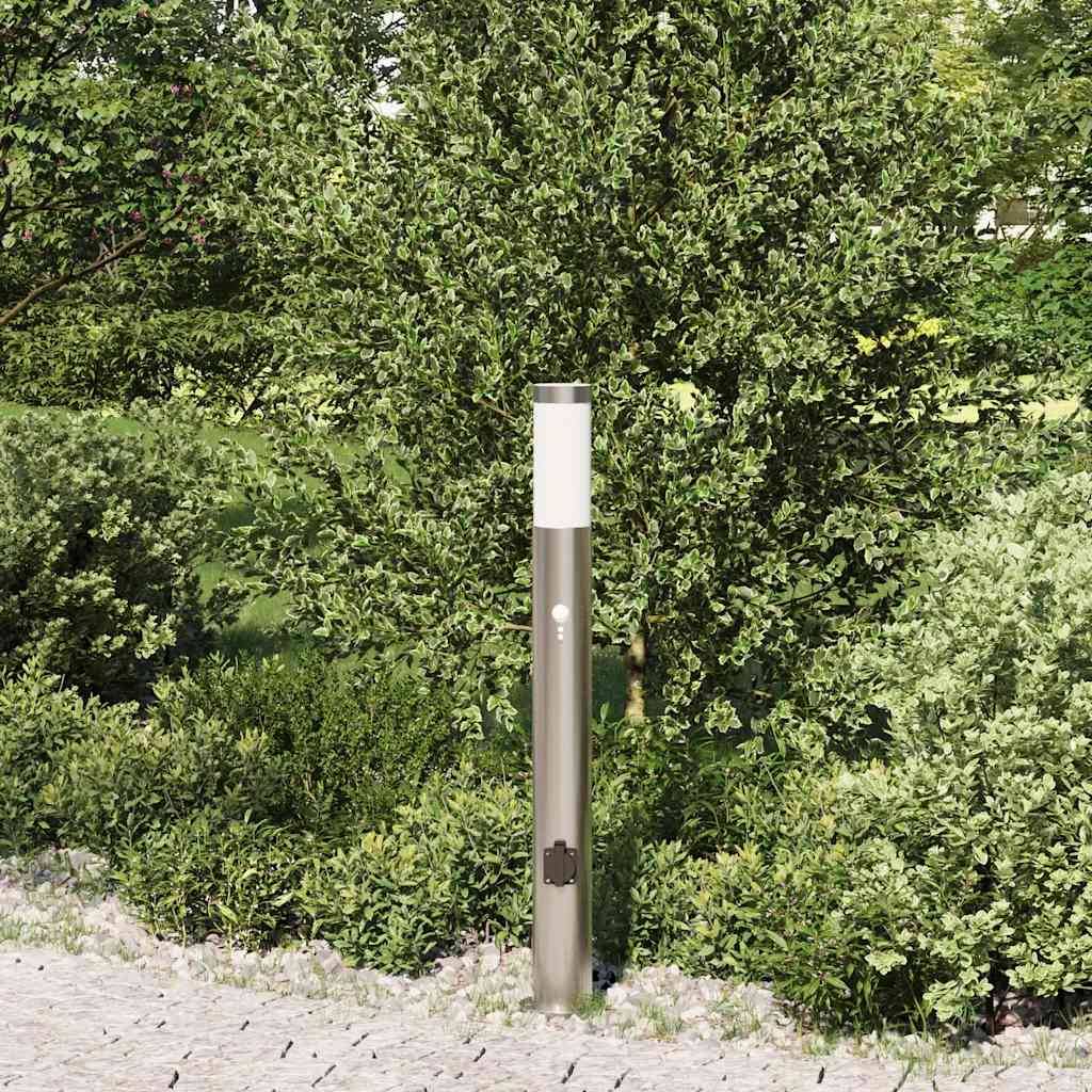 Eine elegante, moderne Solarlampe auf einem Pfahl, umgeben von üppig grünen Büschen auf einem Steinweg, eingebettet in eine sonnendurchflutete Gartenumgebung.