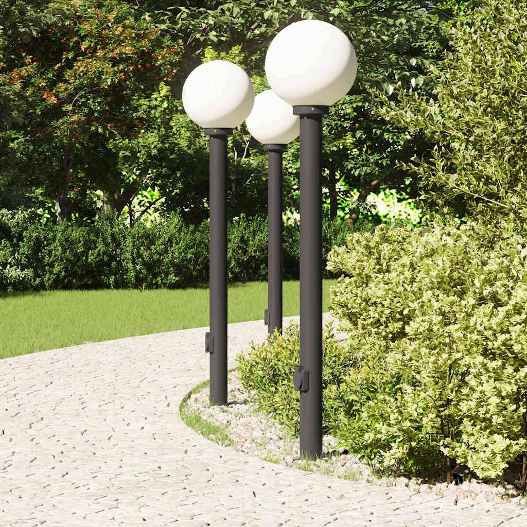 Ein Steinweg windet sich durch einen Garten mit vier kugelförmigen Straßenlampen. Büsche und Bäume sorgen im Hintergrund für Grün.