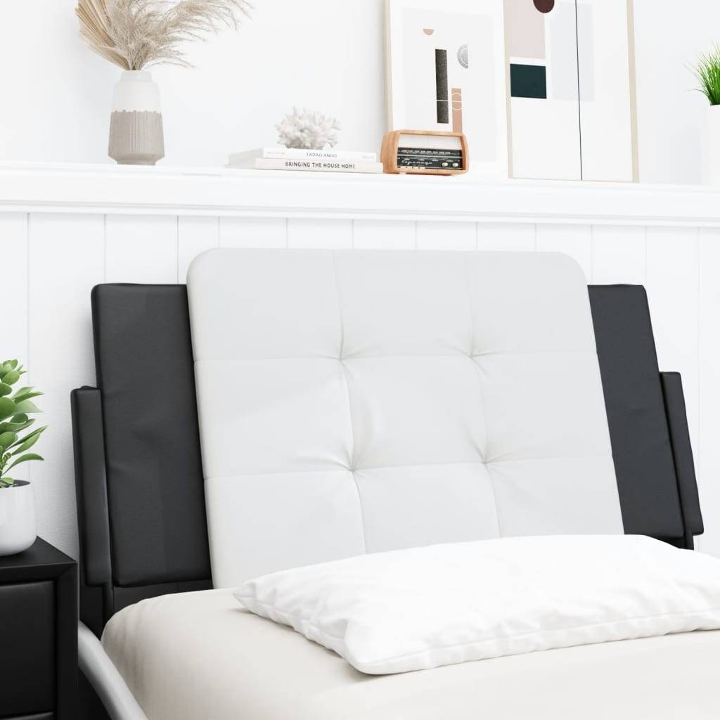 Ein ordentlich gestaltetes Schlafzimmer zeichnet sich durch ein weißes gestepptes Kopfteil, schwarze Seitenpaneele und minimalistische Dekoration aus, darunter eine Vase und abstrakte Kunst.