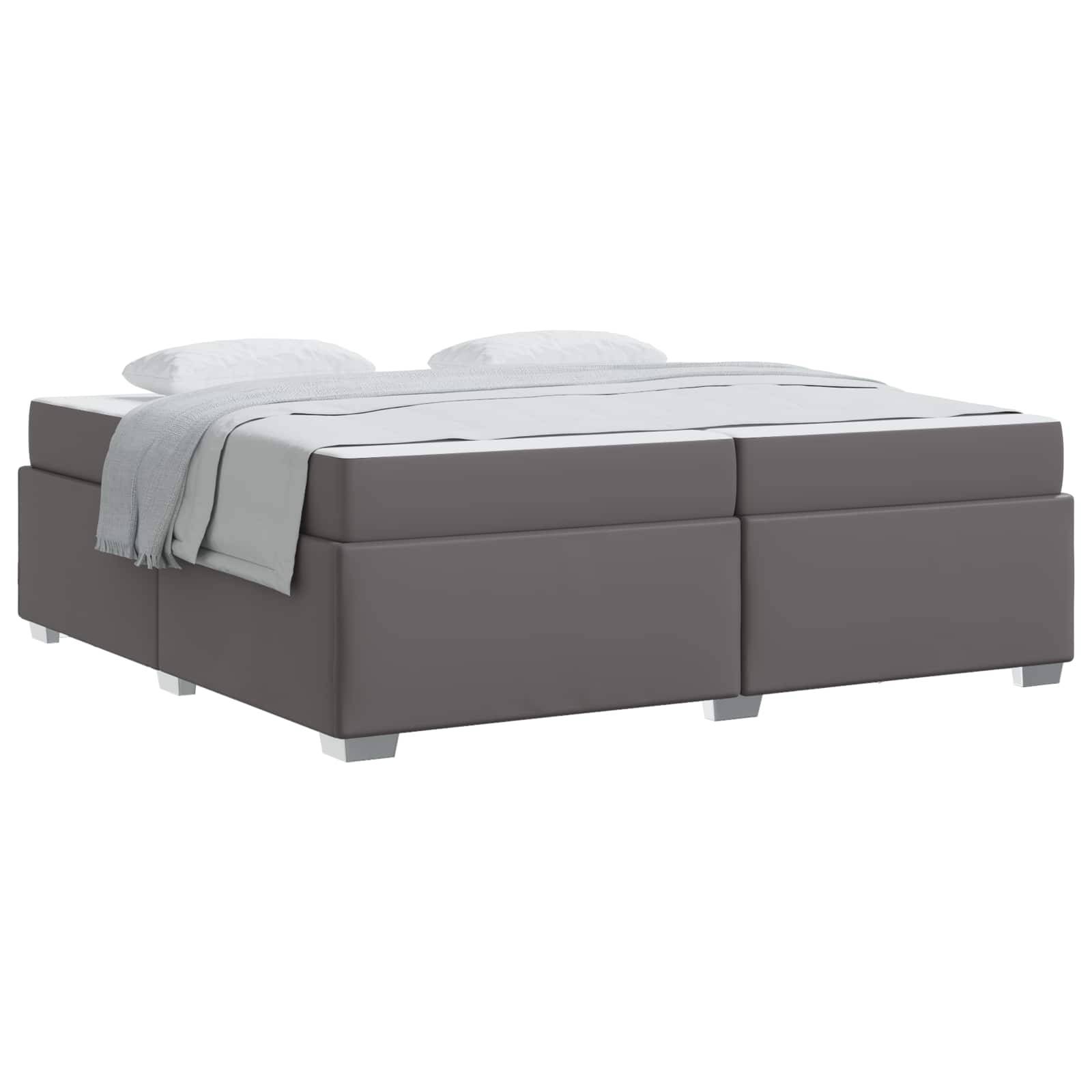 Grau gepolstertes Bett mit Matratze, Kopfteil, Kissen und einer gefalteten Decke auf weißem Hintergrund.