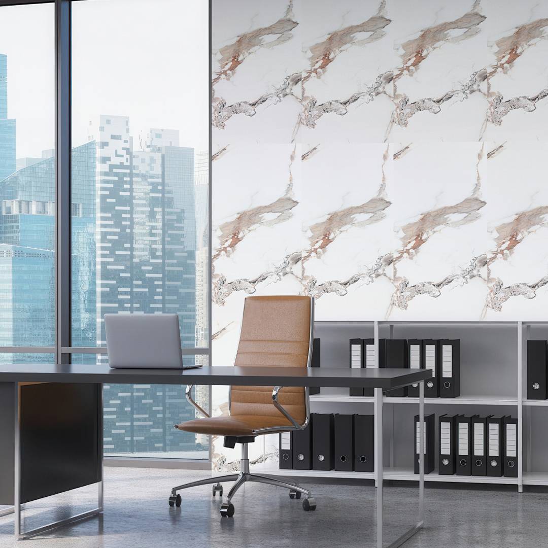 Modernes Büro mit leerem Schreibtisch, Stuhl, Laptop, Aktenschränken und Stadtsilhouette sichtbar durch große Fenster.