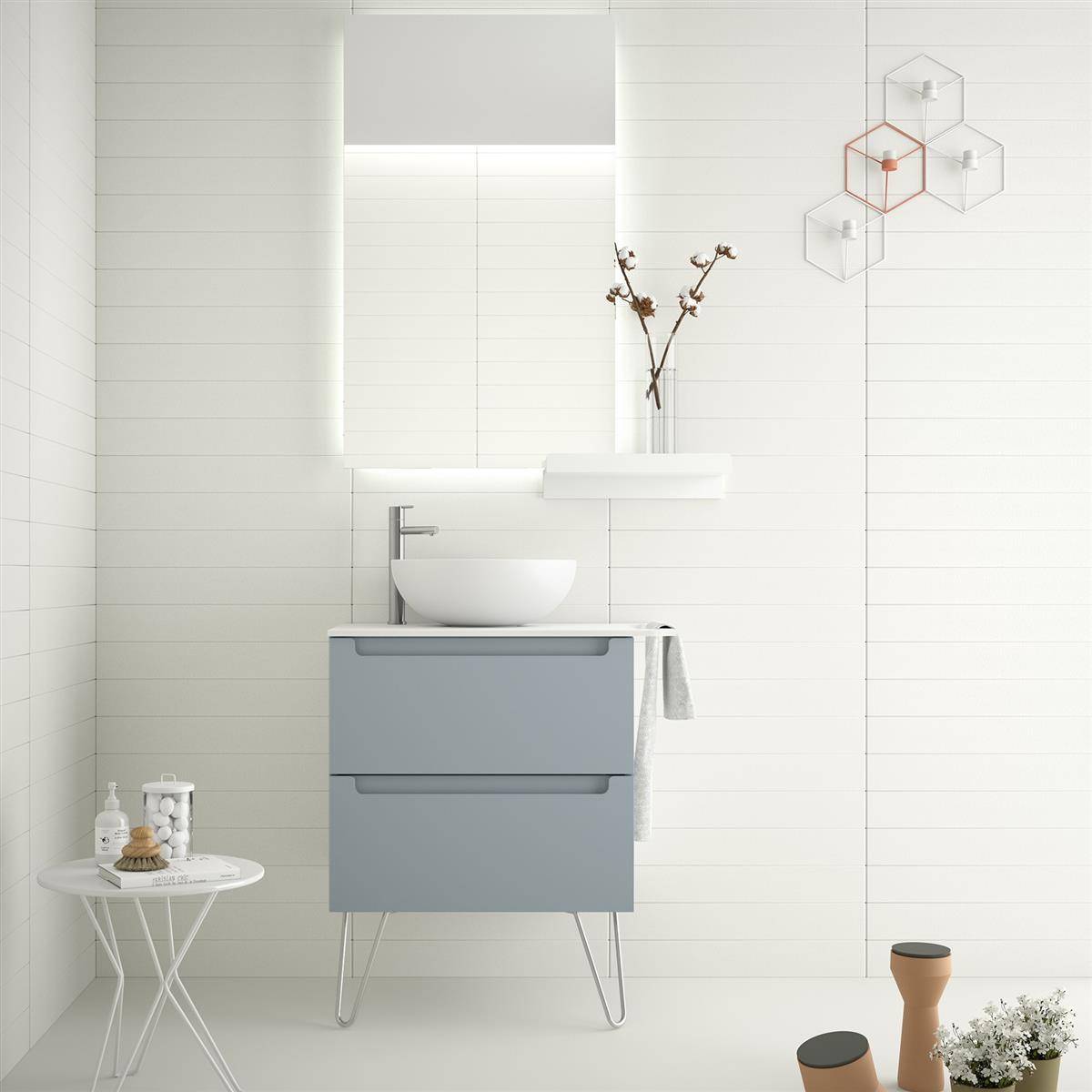 Minimales weißes Badezimmer mit schwebendem grauem Waschtisch, Aufsatzwaschbecken, beleuchtetem Spiegel, Regal mit Zweigen und kleinen Beistelltischen sowie Dekoration.