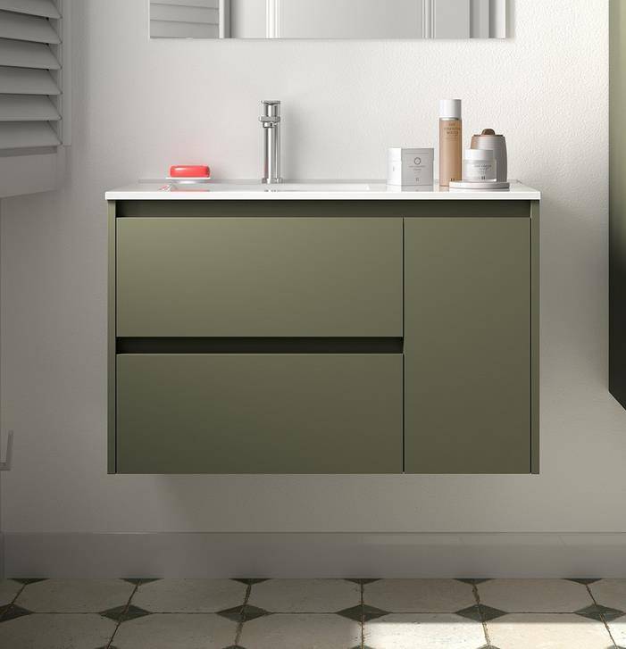 Modernes Badezimmerwaschtisch mit olivgrünen Schränken, weißer Arbeitsplatte, Chromarmatur und Toilettenartikeln, montiert gegen eine helle Wand mit sechseckigem Fliesenboden.