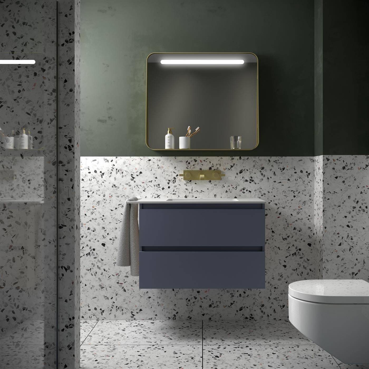 Modernes Badezimmer mit gesprenkelten Fliesenwänden und Boden, schwebendem Waschtisch, beleuchtetem Spiegelschrank, Wandarmatur und teilweise sichtbarem Toilettensitz.