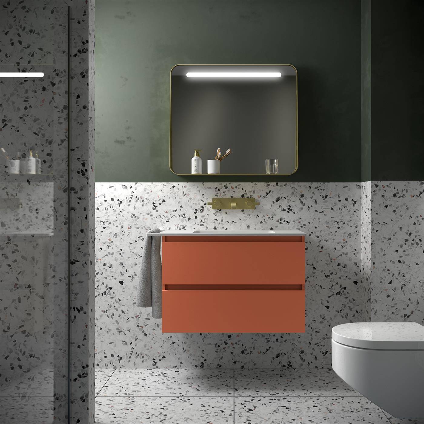 Modernes Badezimmer mit wandmontiertem orangefarbenem Waschtisch, Spiegel, Waschbecken, Terrazzofliesenwänden und -boden sowie einer Toilette auf der rechten Seite.