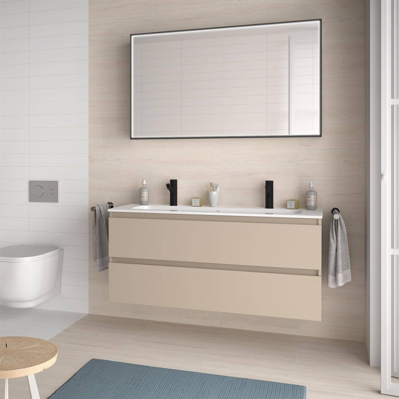Modernes Badezimmer mit schwebendem beigefarbenem Waschtisch, Wandspiegel, Toilette und blauer Badematte; Handtücher hängen auf beiden Seiten.