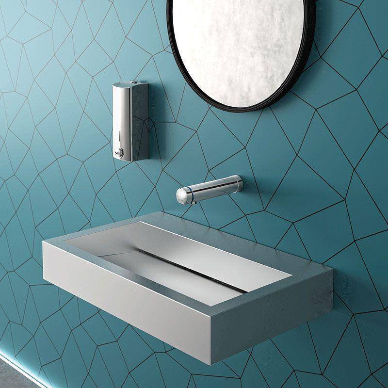 Modernes, an der Wand montiertes Waschbecken mit Spiegel und Armatur an einer blaugrünen geometrisch gefliesten Badezimmerwand.
