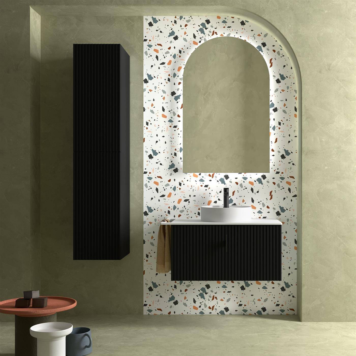 Modernes Badezimmer-Waschtisch mit schwarzem geripptem Schrank, weißer Terrazzo-Bogenwand, rundem Spiegel, Waschbecken und seitlichem Regal an gedämpften grünen Wänden.