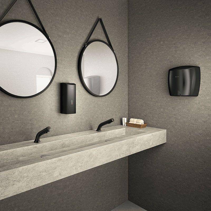 Modernes Badezimmer mit Betonwaschbecken mit doppeltem Waschbecken, zwei runden Spiegeln, schwarzen Armaturen und wandmontierten Seife- und Papiertuchspendern.
