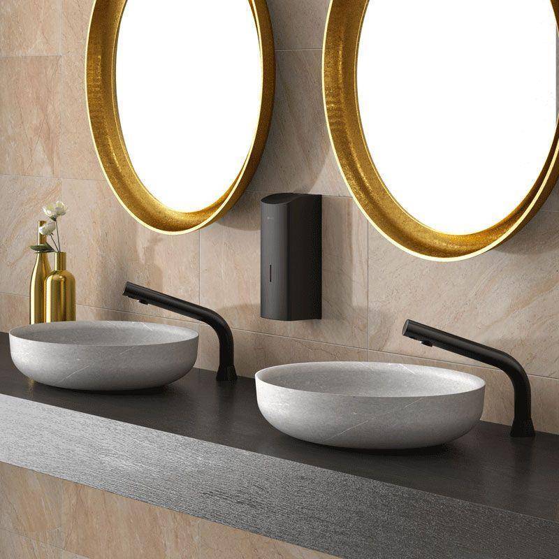 Modernes Badezimmerwaschtisch mit zwei runden Aufsatzwaschbecken, schwarzen Armaturen, goldgerandeten Spiegeln und einem wandmontierten Seifenspender.