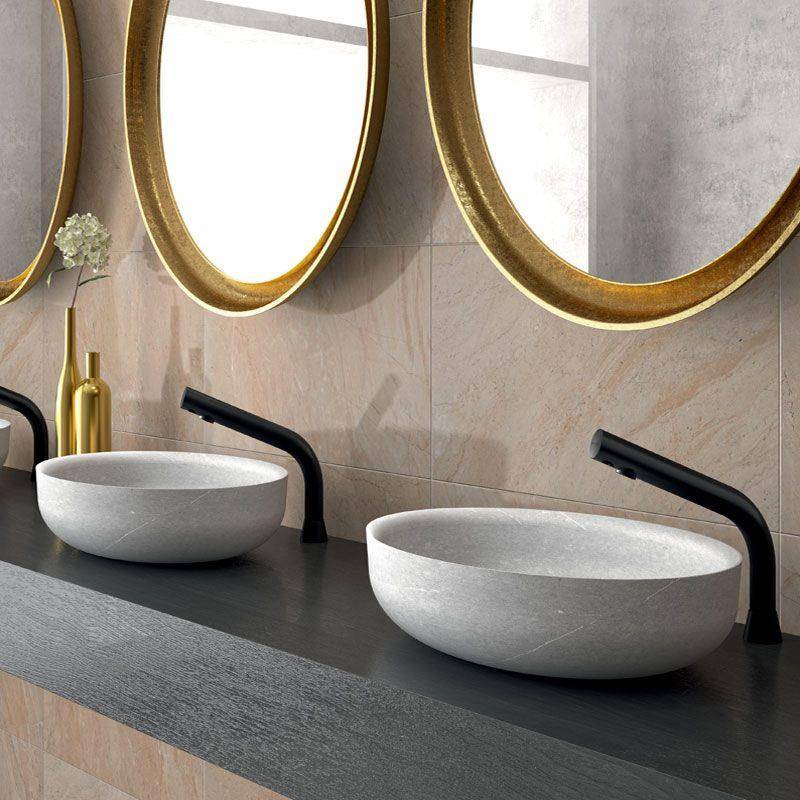 Modernes Badezimmerwaschtisch mit zwei runden weißen Aufsatzwaschbecken, matt schwarzen Armaturen und goldgerahmten Spiegeln über einer dunklen Arbeitsplatte.
