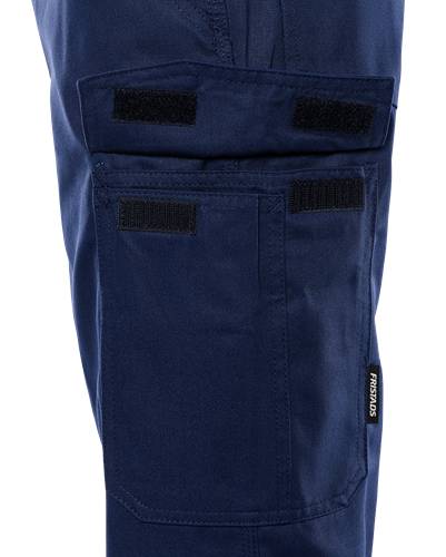 Dunkelblaue Hose mit mehreren Klettverschlusstaschen an der Seite, mit einem kleinen 'Fristads' Etikett, vor schwarzem Hintergrund.