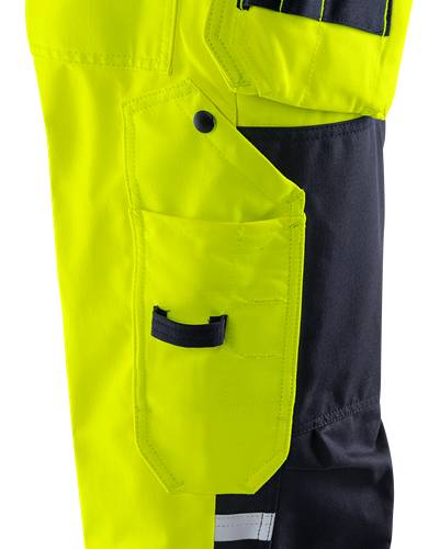 Nahaufnahme einer gelb-schwarzen Arbeitshose mit einer zugeknöpften Tasche, die die Funktionalität und Designmerkmale des Kleidungsstücks hervorhebt.
