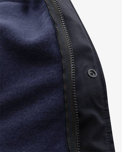 Nahaufnahme einer Jacke, die eine detaillierte Ansicht des Reißverschlusses und der Gewebestruktur zeigt und dabei die Handwerkskunst und Materialqualität hervorhebt.