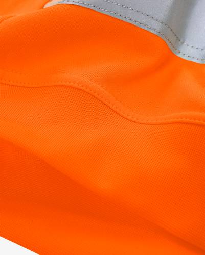 Leuchtend orangefarbener Stoff mit sichtbaren Nähten und Textur, Teil eines Kleidungsstücks.