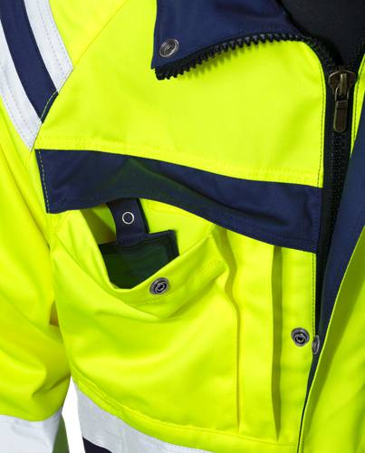 Nahaufnahme einer leuchtend gelben Jacke mit reflektierenden Streifen und einer Reißverschlusstasche, die Arbeitsschutzkleidung mit hoher Sichtbarkeit andeutet.
