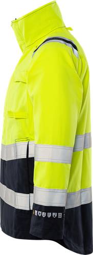 Nahaufnahme einer Warnschutzjacke in leuchtendem Gelb mit reflektierenden Streifen, getragen von einer Person. Die Jacke scheint Teil einer Arbeitskleidung zu sein.