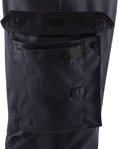 Eine Nahaufnahme einer Tasche einer dunkel gefärbten taktischen Hose mit einer Klappe, die durch Klettverschluss und Knöpfe gesichert ist und robustes Material und Design präsentiert.