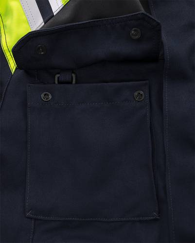 Eine Nahaufnahme einer dunkel gefärbten Jacke mit einer geknöpften Tasche und sichtbaren hellgelben Nähten am oberen Rand.