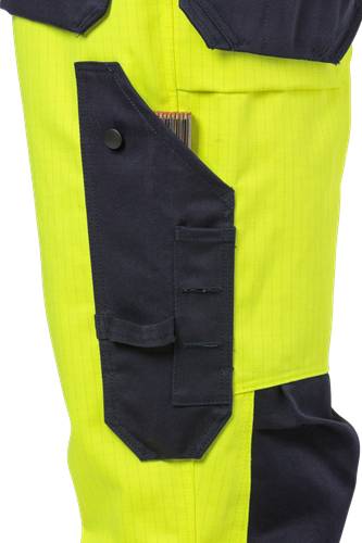 Eine Nahaufnahme eines gelben und navy-blauen Kleidungsstücks aus Stoff mit einem teilweise sichtbaren Stift in einer kleinen Tasche, höchstwahrscheinlich Arbeitskleidung oder Uniform.