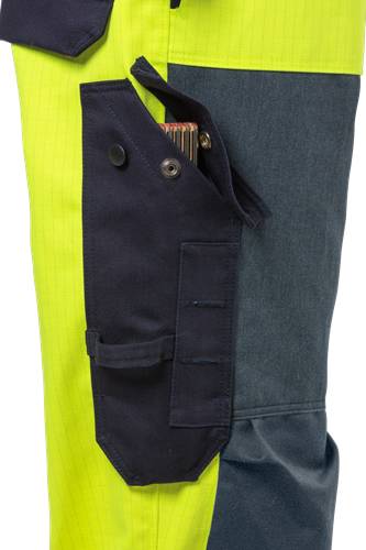Eine Nahaufnahme einer blauen Tasche an einer marineblauer Hose, in der eine Zigarettenschachtel steckt. Die Hose hat einen kontrastierenden gelben Streifen neben der Tasche.