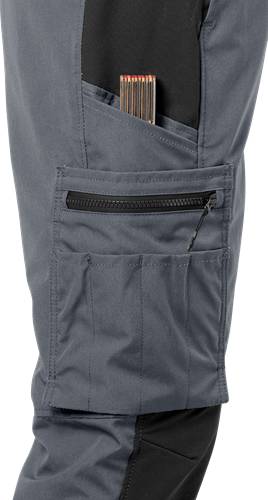 Nahaufnahme einer grauen Tasche mit einem Reißverschluss, der teilweise geöffnet ist und einen Werkzeug mit Holzgriff im Inneren zeigt. Der Stoff wirkt robust und strapazierfähig.