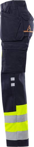 Eine Nahaufnahme einer marineblauen Uniform mit reflektierenden Streifen, die Arbeitskleidung zeigt, die für Sicherheit und Sichtbarkeit konzipiert ist.