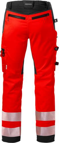 Rote Hose mit schwarzer Einfassung an den Seiten, versehen mit Taschen und Reißverschlüssen, vor einem schwarzen Hintergrund präsentiert.