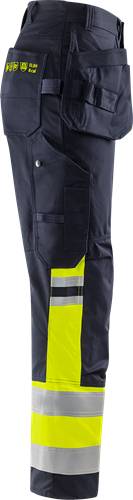 Eine Detailaufnahme eines marineblau-farbenen Hosenbeinabschnitts mit einem hochreflektierenden gelben Warnstreifen in Kniehöhe und einer seitlichen Tasche.