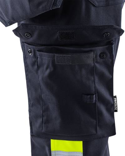 Eine Nahaufnahme einer schwarzen taktischen Tasche an einem Kleidungsstück mit Klettverschluss-Klappen und Knöpfen, die ein strapazierfähiges Fabric-Material und detaillierte Nähte zeigt.