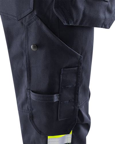 Nahaufnahme eines dunkelblauen Kleidungsstücks mit einer auffälligen Tasche mit Knopfverschluss und detaillierter Nahtführung.