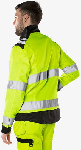 Das Bild zeigt eine Person, die eine signalgelbe und silbern reflektierende Warnschutzjacke trägt, was die Sicherheitsarbeitskleidung zur Verbesserung der Sichtbarkeit betont.