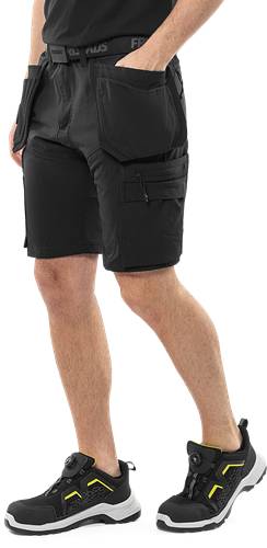 Eine Person trägt schwarze Cargo-Shorts, die ein praktisches Design mit mehreren Taschen betonen. Das Bild konzentriert sich auf den unteren Körperbereich.