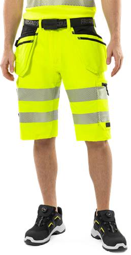 Eine Person trägt gelbe Sicherheitskurzhosen mit reflektierenden Streifen und unterstreicht damit den Fokus auf Sichtbarkeit und Sicherheit.